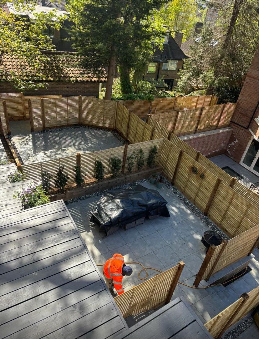 Raised timber decking beside a fenced patio garden